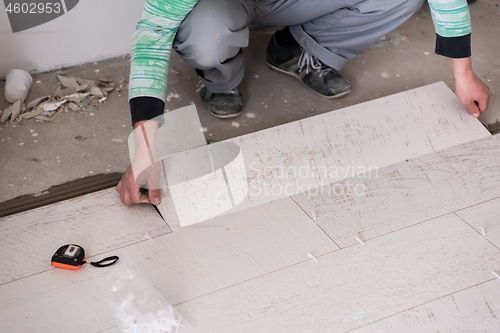 Image of worker installing the ceramic wood effect tiles on the floor