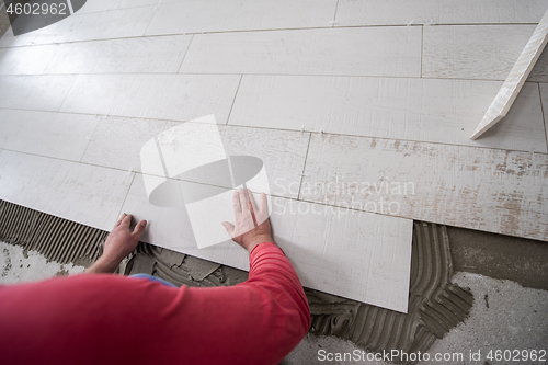 Image of worker installing the ceramic wood effect tiles on the floor