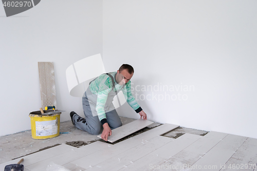 Image of worker installing the ceramic wood effect tiles on the floor