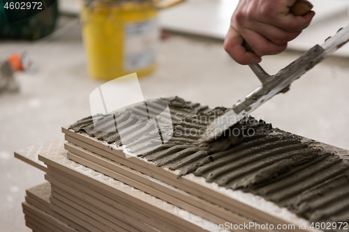 Image of worker installing the ceramic wood effect tiles on the floor