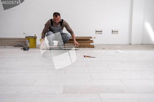 Image of worker installing the ceramic wood effect tiles on the floor