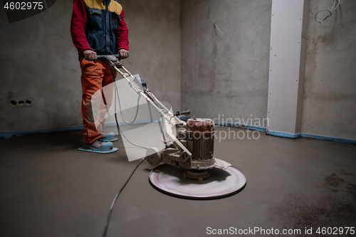 Image of worker performing and polishing sand and cement screed floor