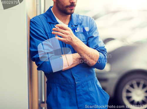 Image of close up of auto mechanic smoking cigarette