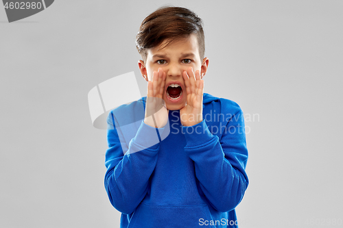 Image of angry boy in blue hoodie shouting