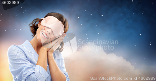 Image of happy young woman in pajama and eye sleeping mask