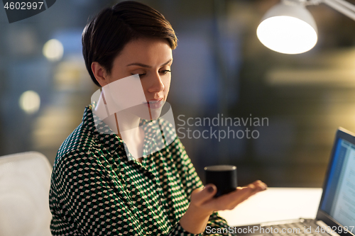 Image of businesswoman using smart speaker at night office