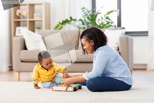 Image of mother and baby playing with toy blocks at home