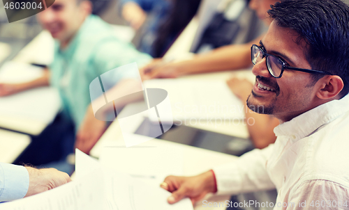 Image of happy student with exam test or handout at lecture