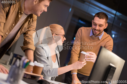 Image of business team with coffee working at night office