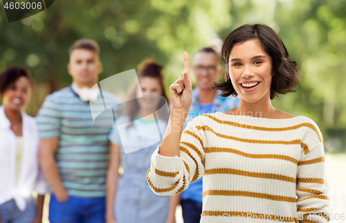 Image of happy woman showing one finger or pointing up