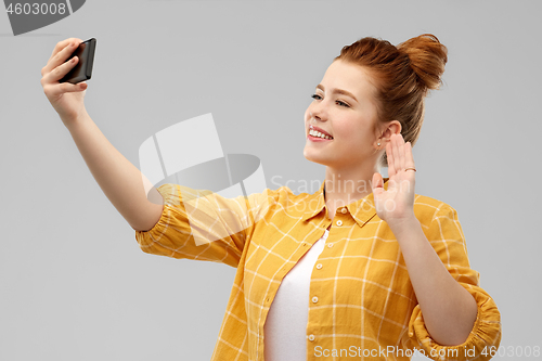 Image of redhead teenage girl taking selfie by smartphone