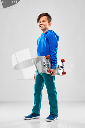 Image of smiling boy in blue hoodie with skateboard