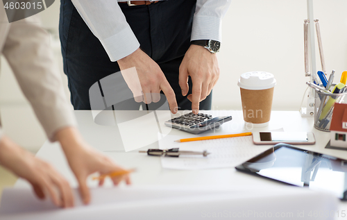 Image of close up of businessman with calculator at office
