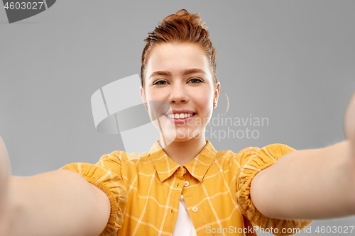 Image of smiling red haired teenage girl taking selfie