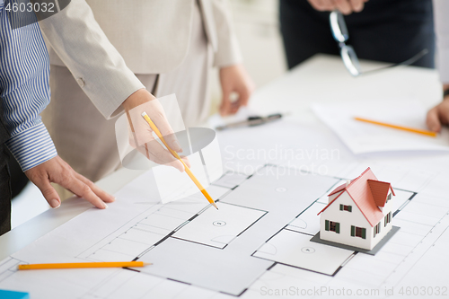 Image of close up of architects with blueprint at office