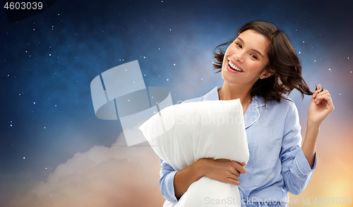 Image of happy woman in pajama with pillow over night sky