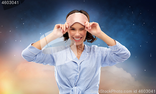 Image of happy young woman in pajama and eye sleeping mask