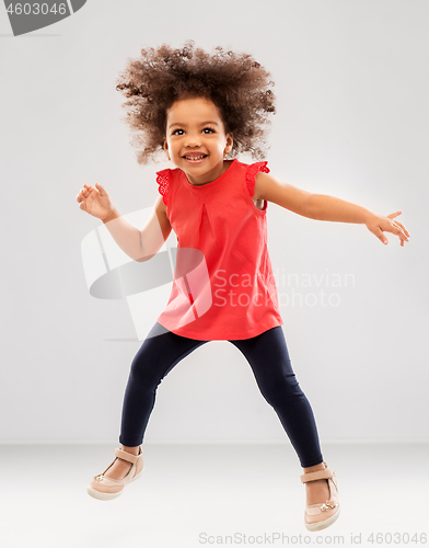 Image of happy little african american girl jumping