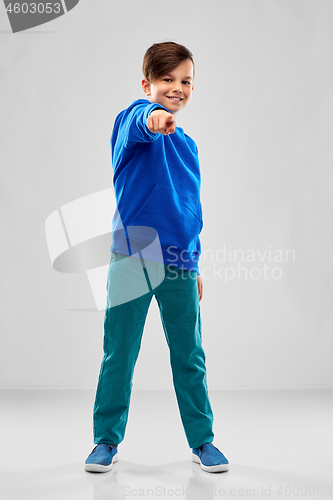 Image of smiling boy in blue hoodier pointing finger