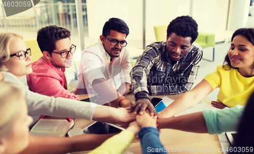 Image of group of international students with hands on top