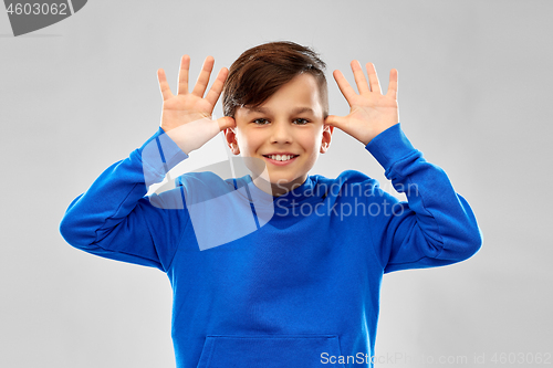 Image of happy boy having fun and making big ears