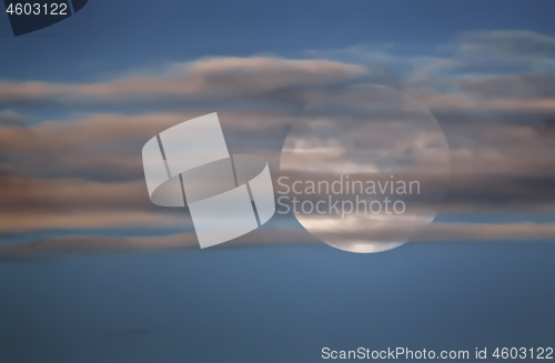 Image of Full Moon In The Sky Behind The Clouds