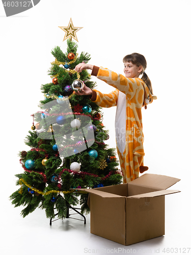 Image of Nine-year-old girl with a smile dresses up The Christmas tree