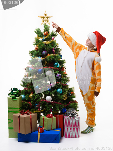 Image of Girl shows off star on Christmas tree