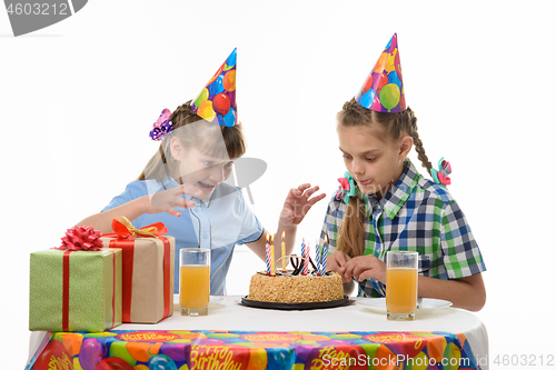 Image of Two girls want sweet and are happy to throw themselves on a birthday cake