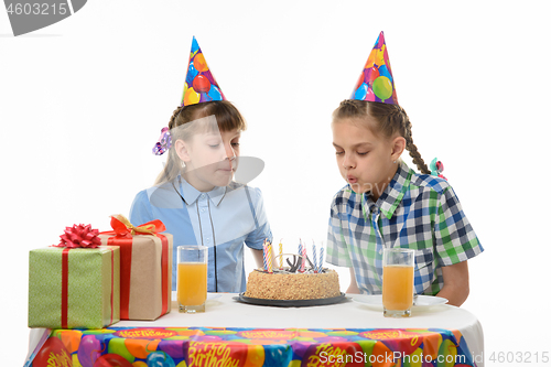 Image of Children blow out candles on a birthday cake