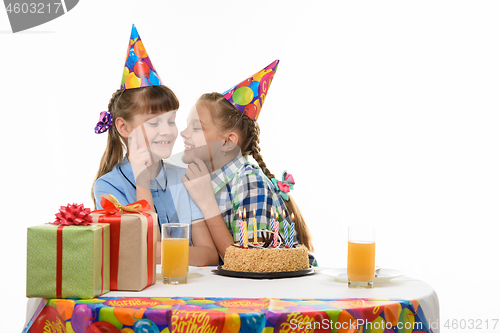 Image of Children keep secrets and talk while sitting at the holiday table