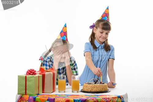Image of Girl puts candles on a birthday cake