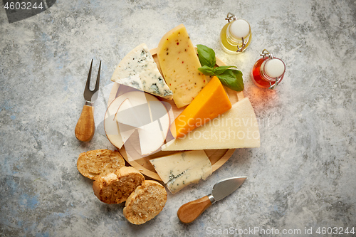 Image of Various types of cheese served on rustic wooden board