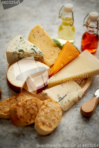 Image of Various types of cheese served on rustic wooden board