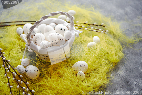 Image of Easter white dotted Eggs in the nest and spring yellow grass