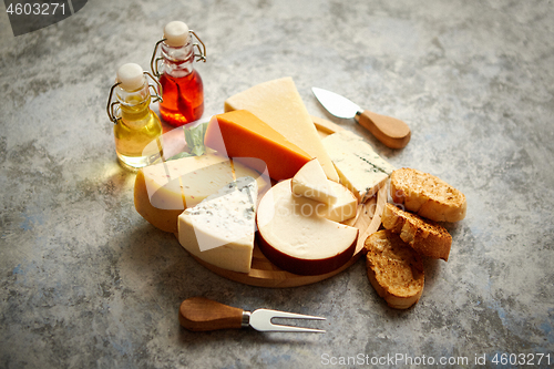 Image of Various types of cheese served on rustic wooden board