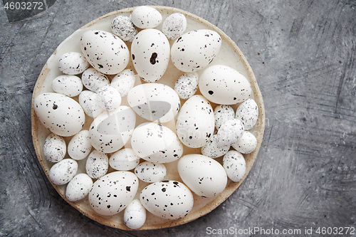 Image of Composition of white traditional dotted Easter eggs in white ceramic plate