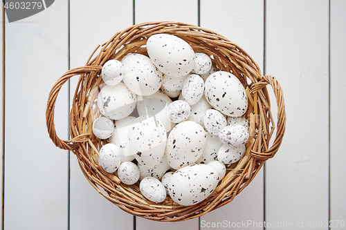 Image of Basket of white dotted Easter eggs in brown wicker basket