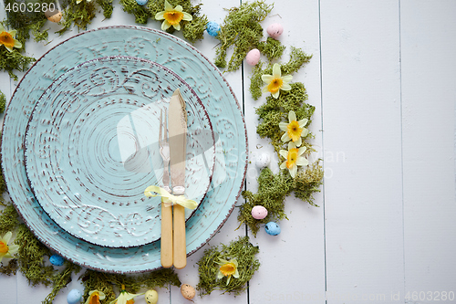 Image of Easter table setting with flowers and eggs. Empty decorative ceramic plates