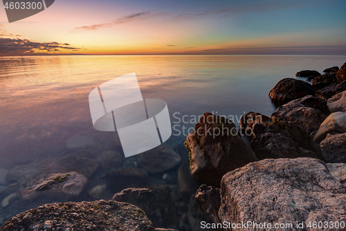 Image of Calm beautiful evening seascape, in the foreground huge stones