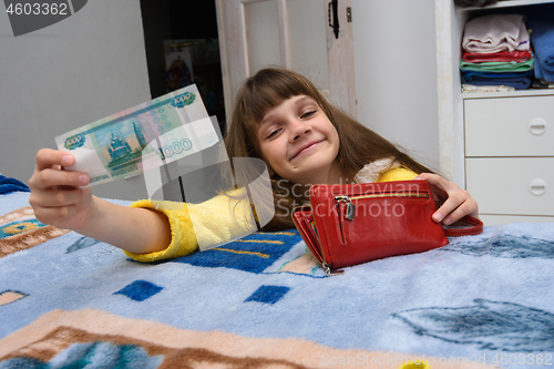 Image of A girl asks for a thousand rubles, pulling them out of moms purse