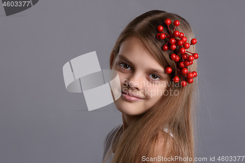 Image of Portrait of a beautiful teenage girl with a bunch of berries in her hand and in her hair