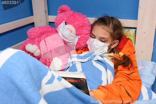 Image of Girl and plush toy in medical masks in bed read a book