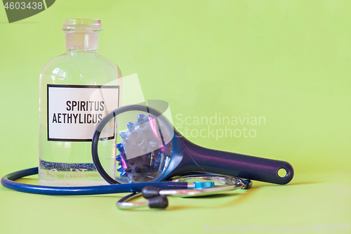 Image of Ethanol in a bottle on the table with of microscope virus close up, stethoscope and loupe. Coronavirus concept