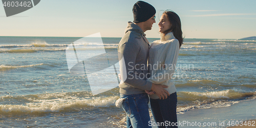 Image of Couple having fun on beautiful autumn day at beach