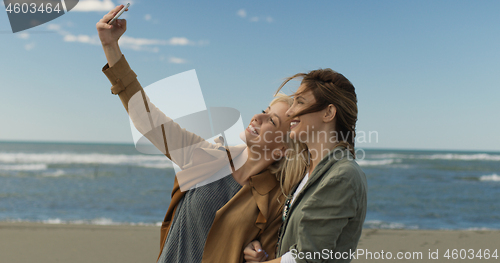 Image of Girls having time and taking selfie on a beach