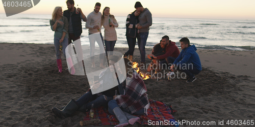 Image of Friends having fun at beach on autumn day