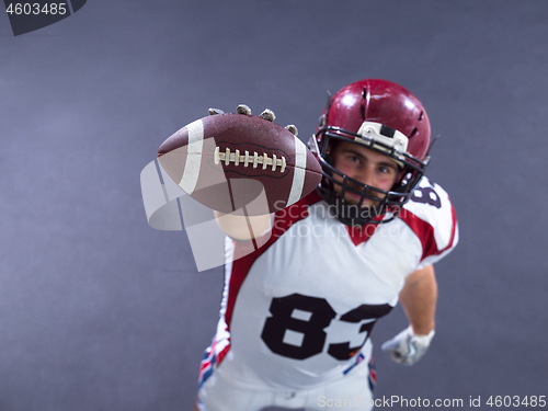 Image of american football player showing football to camera