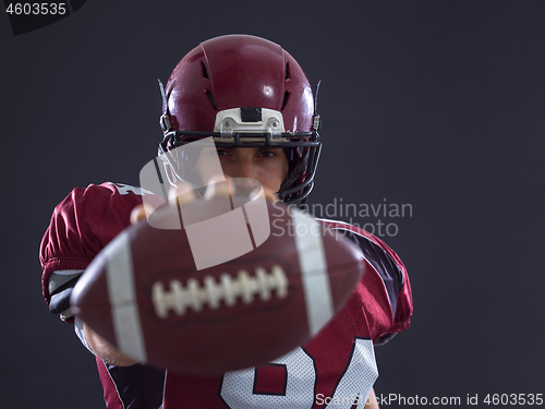 Image of american football player showing football to camera