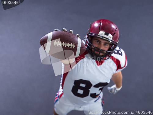 Image of american football player showing football to camera